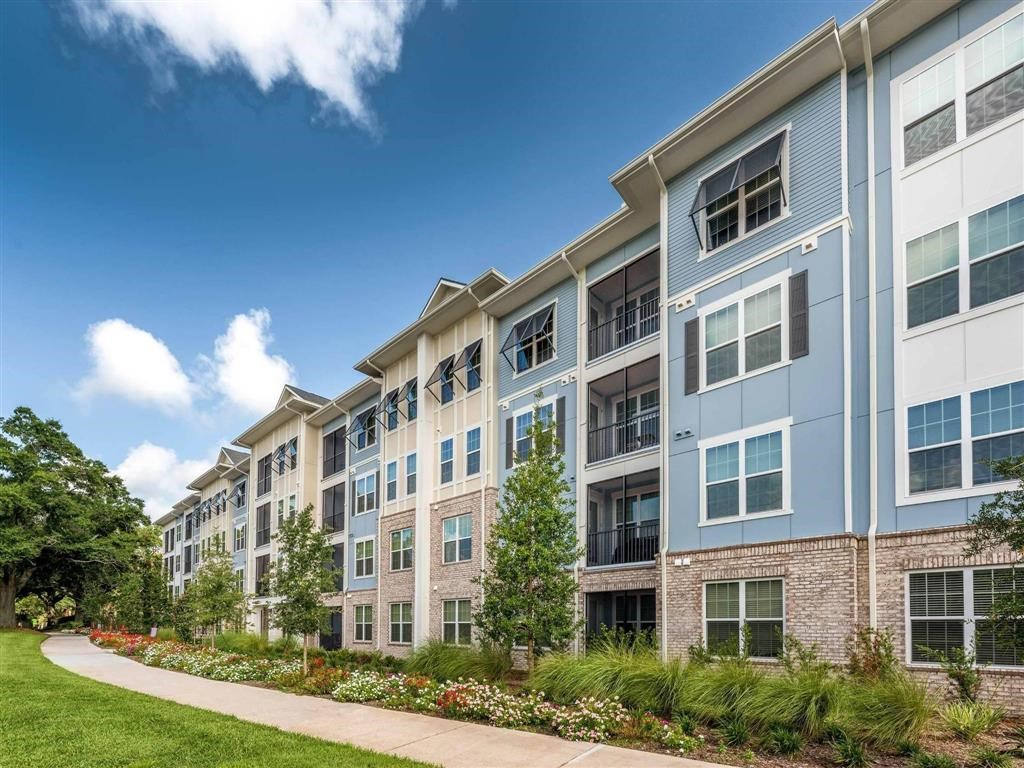 an exterior view of an apartment building with a sidewalk