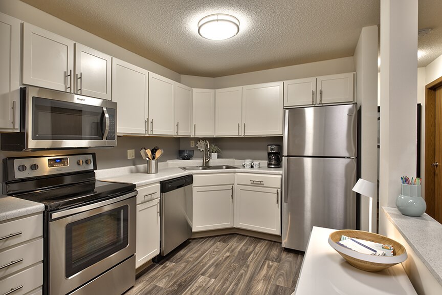 a kitchen with stainless steel appliances and white cabinets