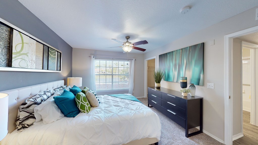 a bedroom with a large bed and a ceiling fan