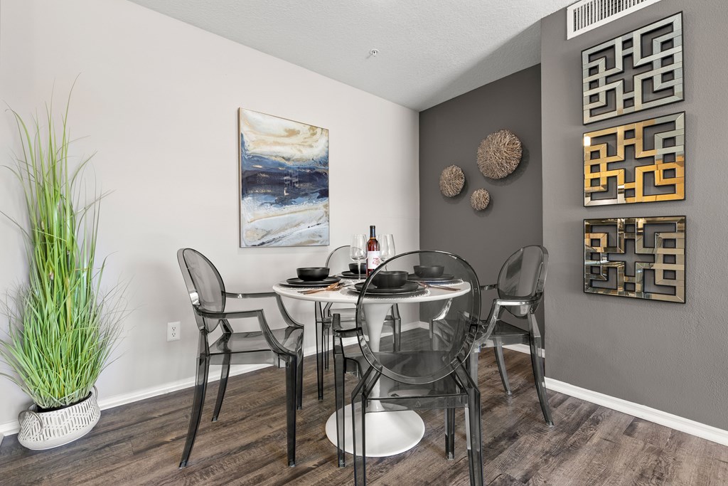 a dining area with a glass table and metal chairs