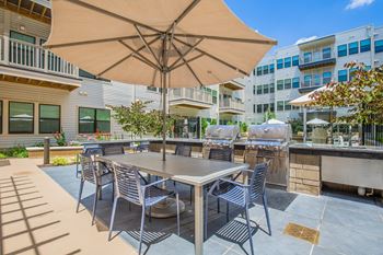 A patio with a table and chairs under an umbrella.
