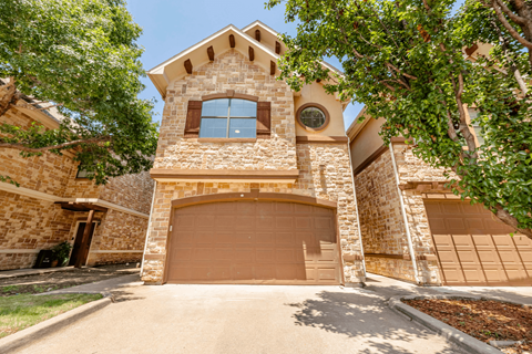 A house with a stone facade and a brown garage door.