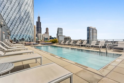 A pool area with a view of the city skyline.