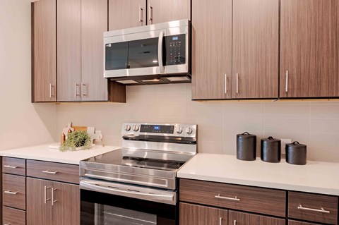 A modern kitchen with a stainless steel stove and microwave above it.