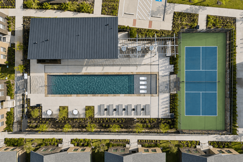 A modern building with a green tennis court.