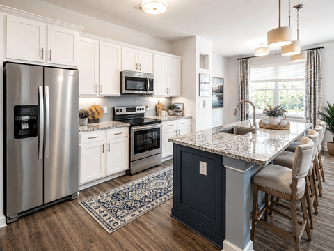 A kitchen with a large island and stainless steel appliances.