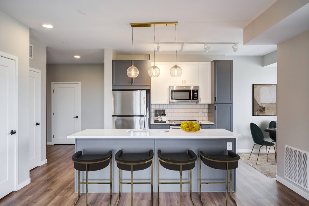a kitchen with a large center island with four stools