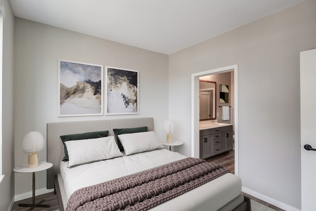 a bedroom with a large bed and a bathroom in the background