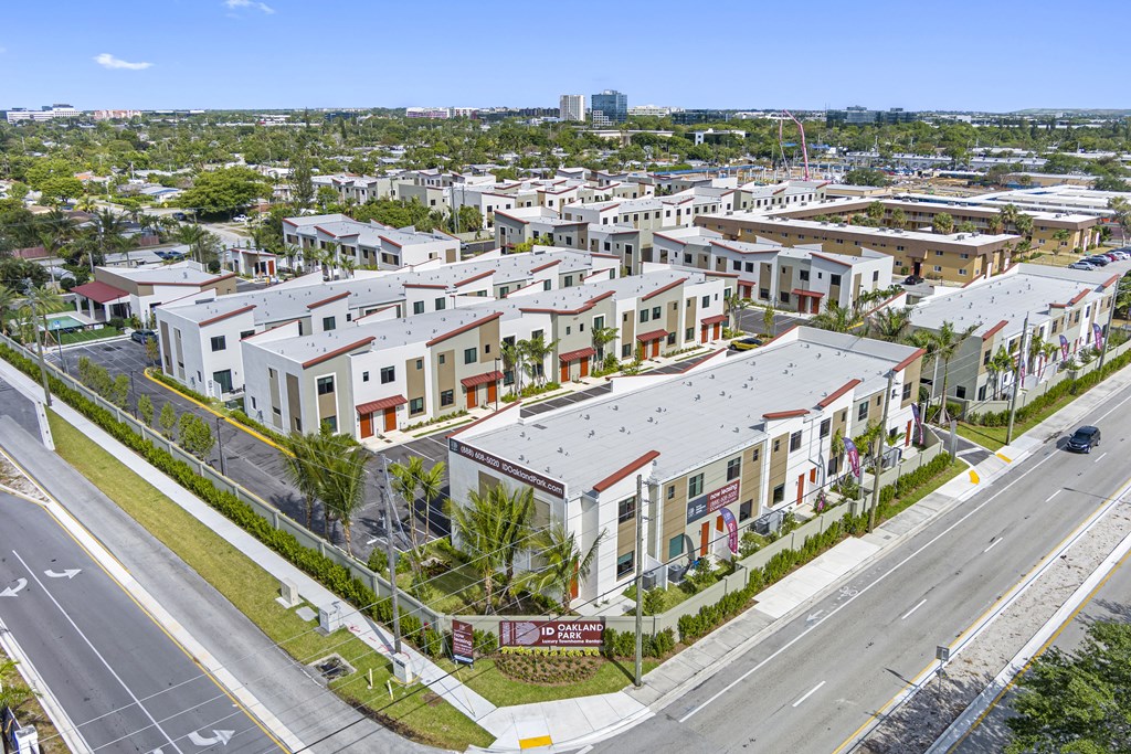 an aerial view of a neighborhood of townhouses and cars on a street