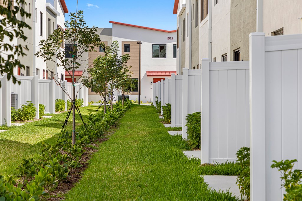 a grassy path in front of an apartment building