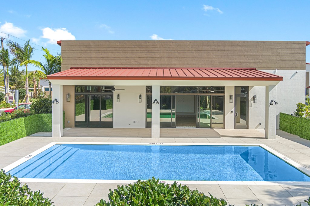 a swimming pool in front of a house with a pool