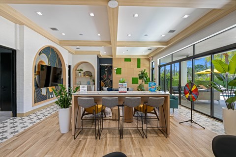 a kitchen with a bar and chairs in front of a window