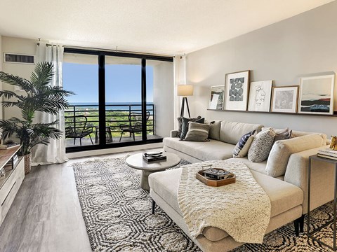 a living room with a couch and a chair and a balcony