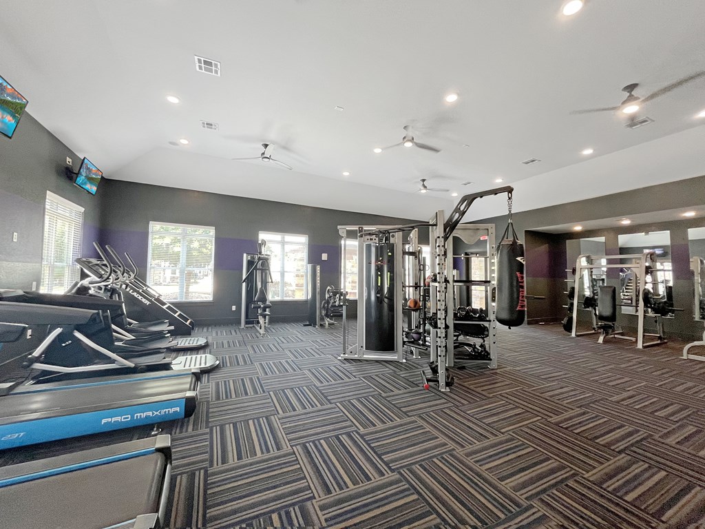 spacious gym with cardio machines and weights