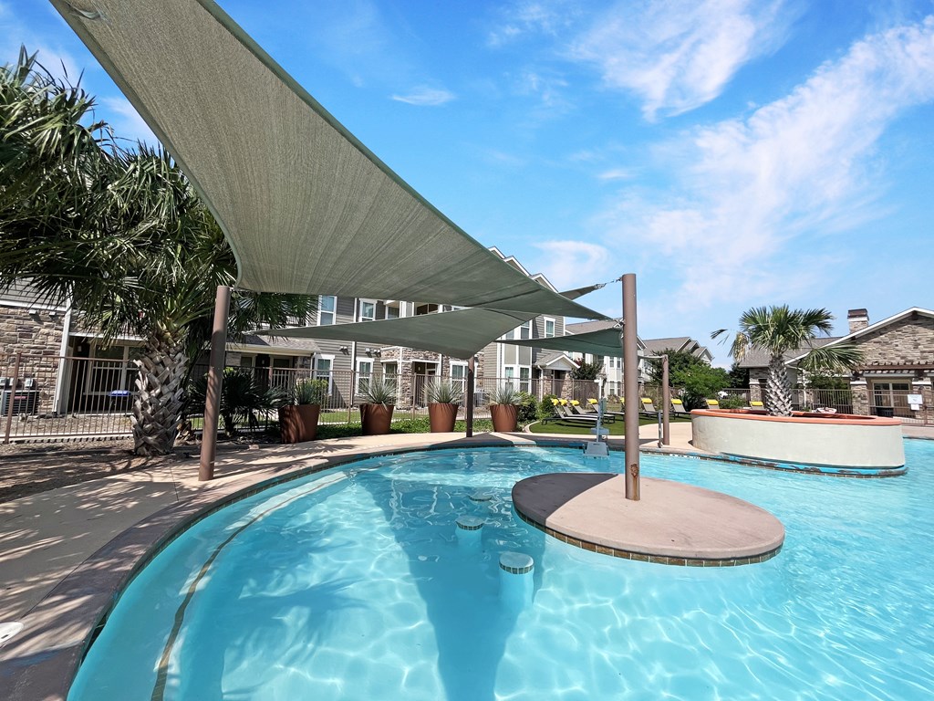 a large swimming pool with canopies and tanning deck