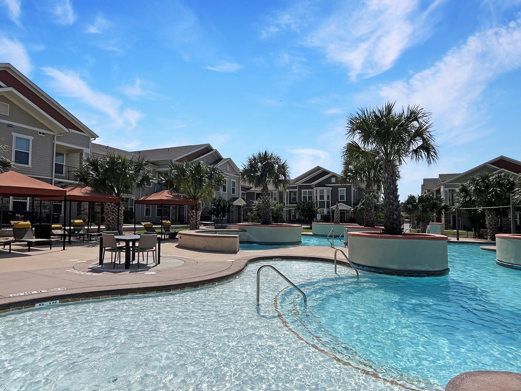 Shallow sun shelf for splashing and relaxing. Residents can enjoy tables and cabanas behind the pool.