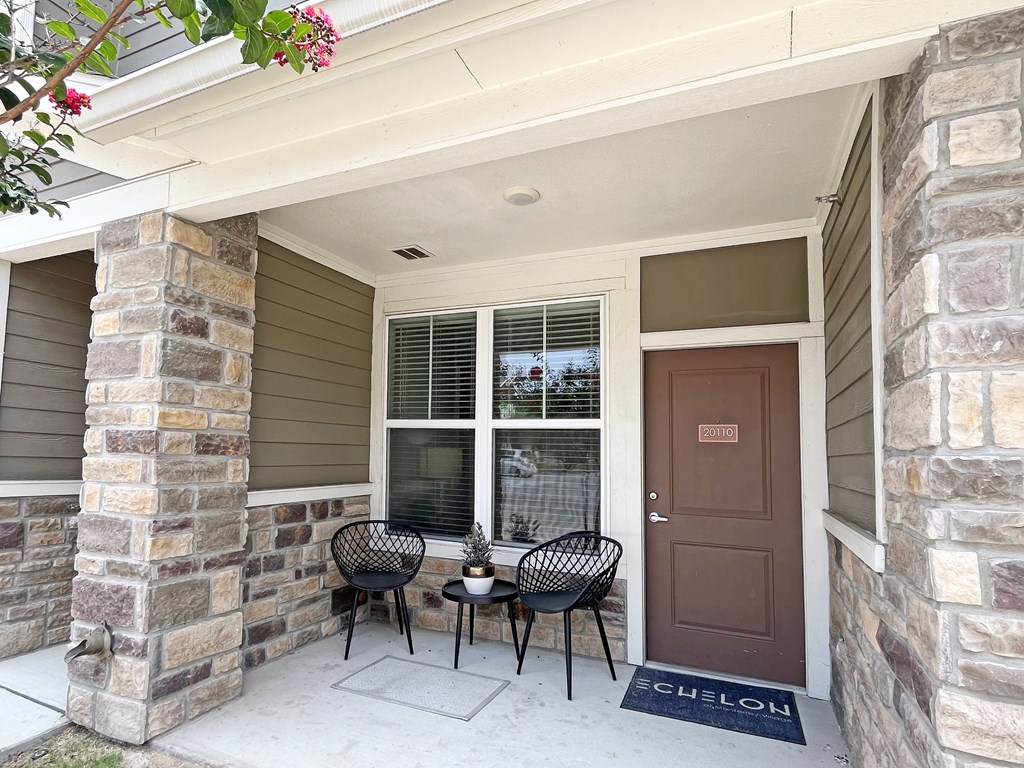 Private front porch of an apartment, fitting two chairs and a table