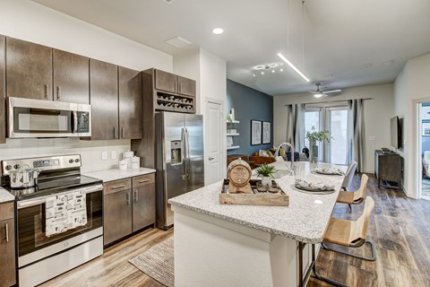 a kitchen with stainless steel appliances and a marble counter top