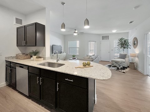 A modern kitchen with dark brown cabinets and a white countertop.
