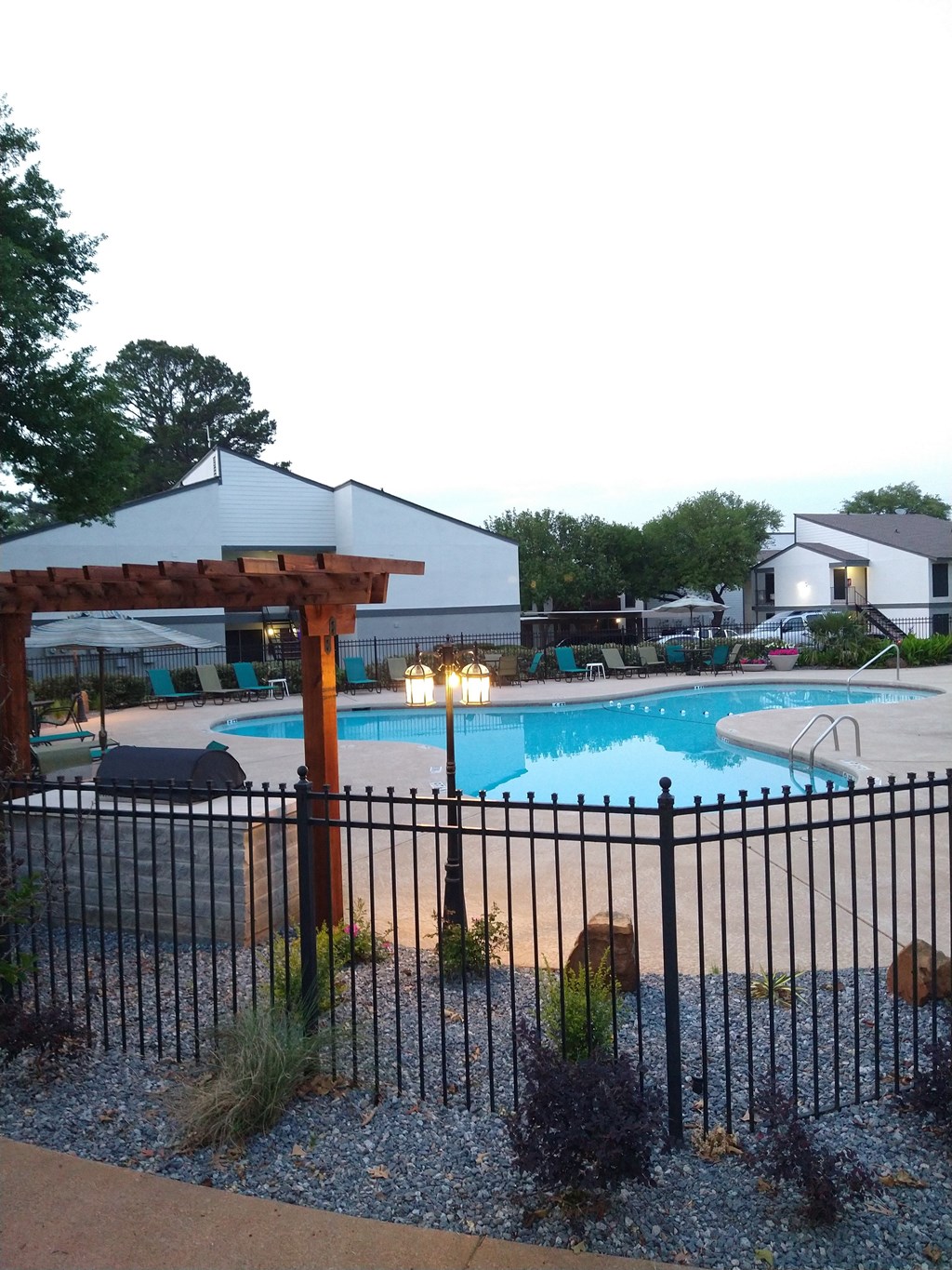 a swimming pool with a pavilion and a fence around it