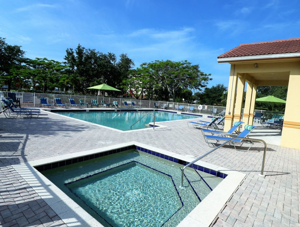 Pool area heated jacuzzi spa with lounge seatings and umbrellas