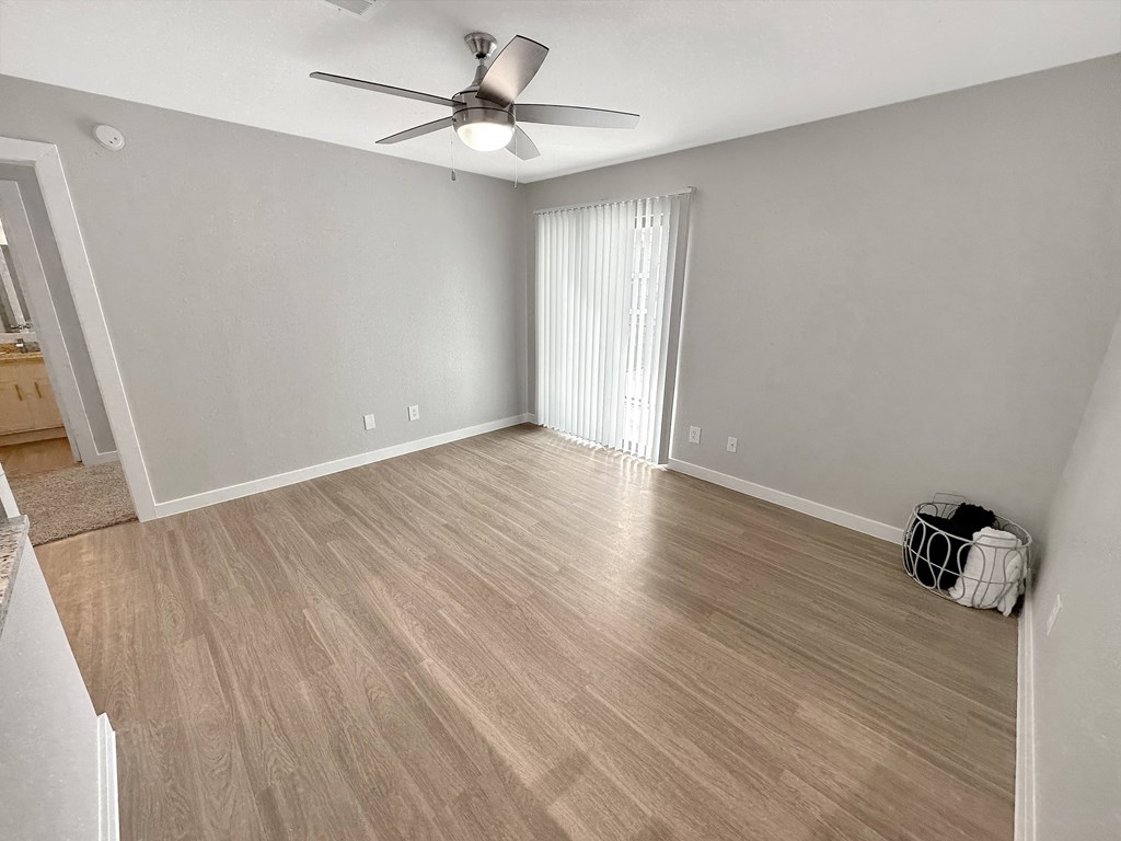 a bedroom with a ceiling fan and hardwood flooring