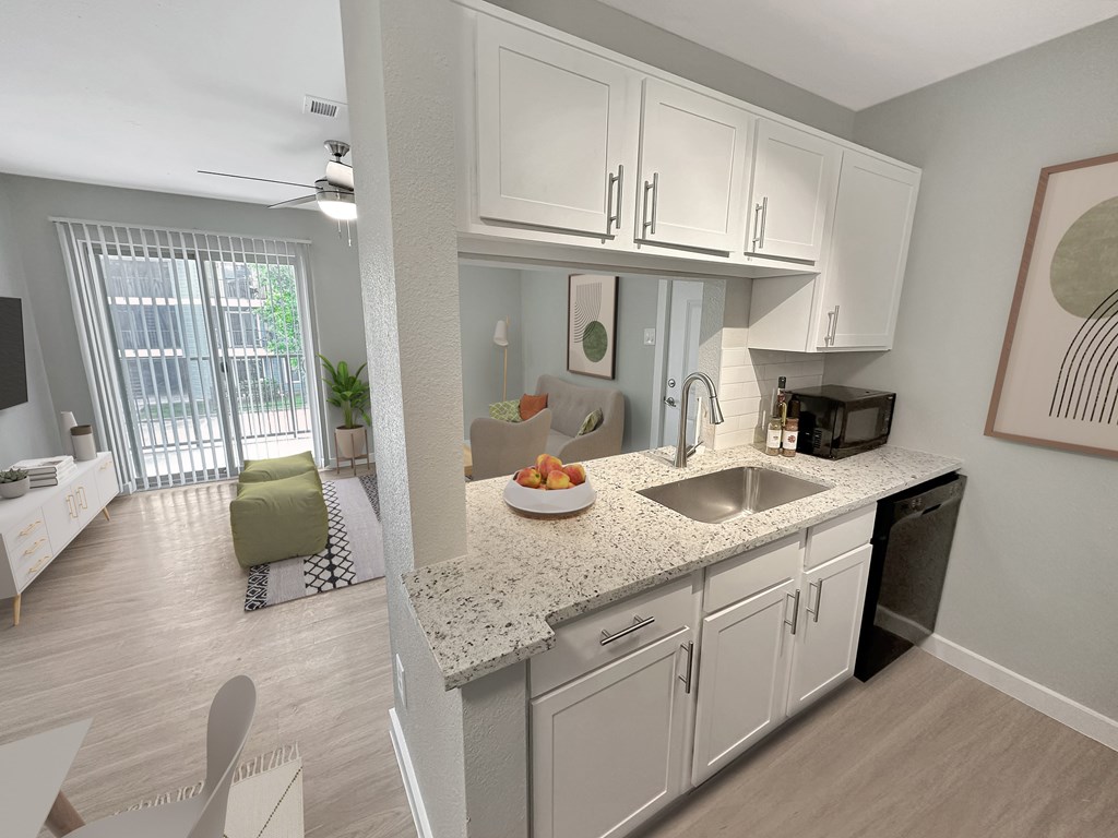 a kitchen with white cabinets and a granite counter top