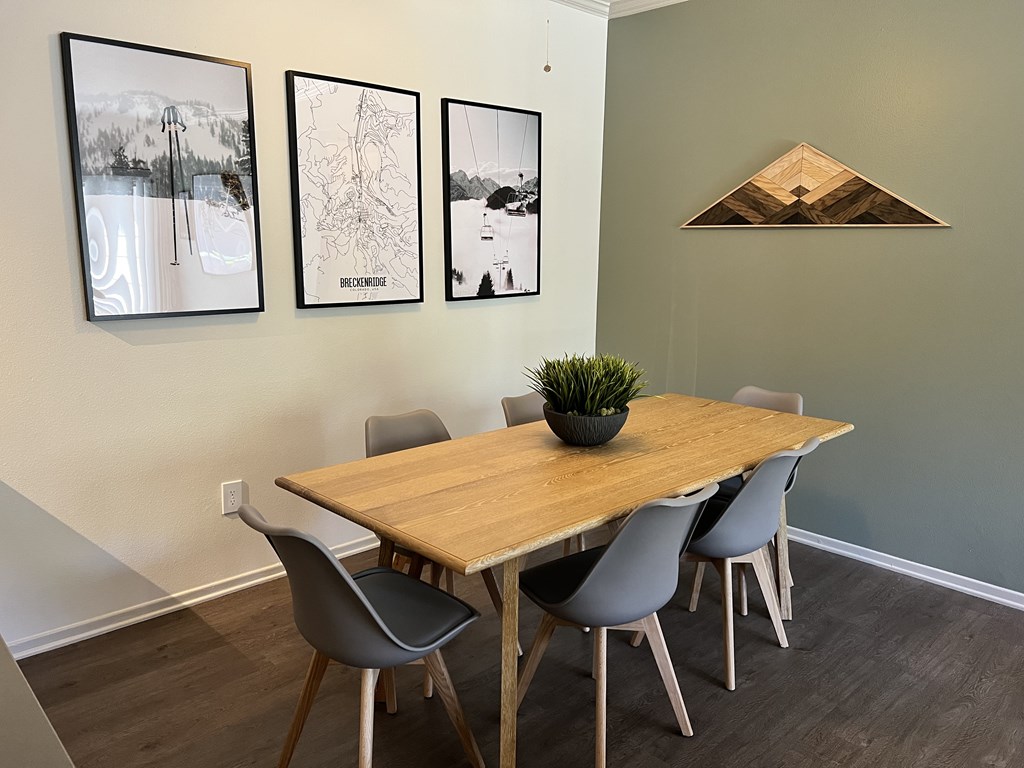 a dining room with a wooden table and grey chairs