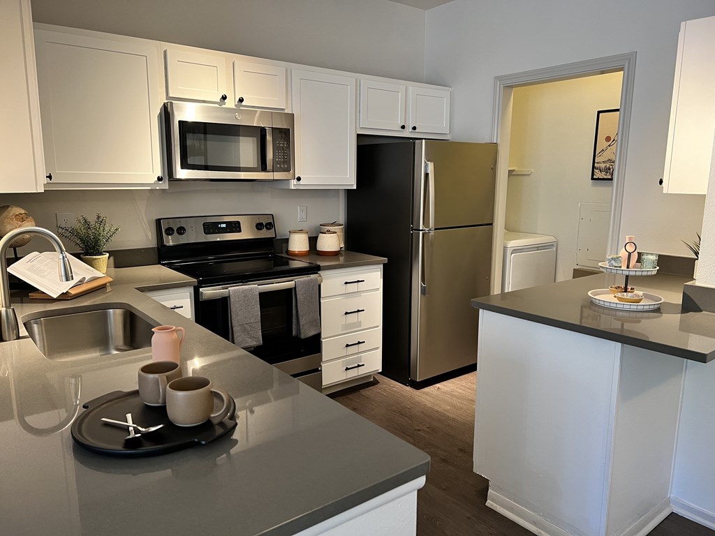 a kitchen with white cabinets and stainless steel appliances