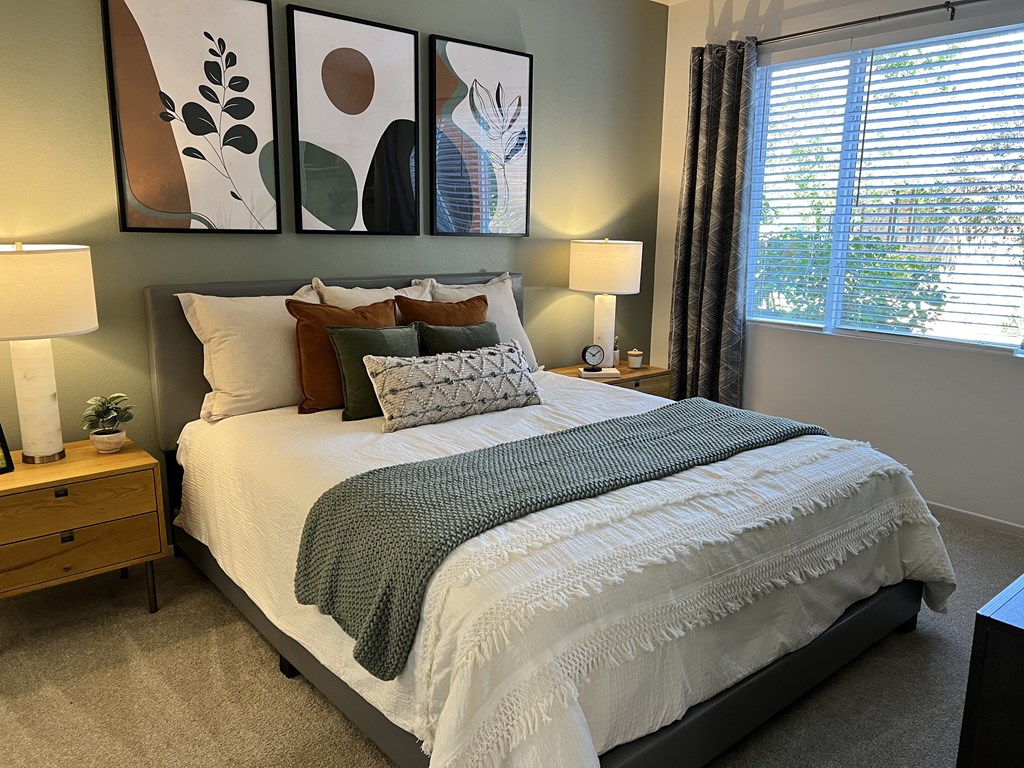 a bedroom with a bed and two night stands with lamps