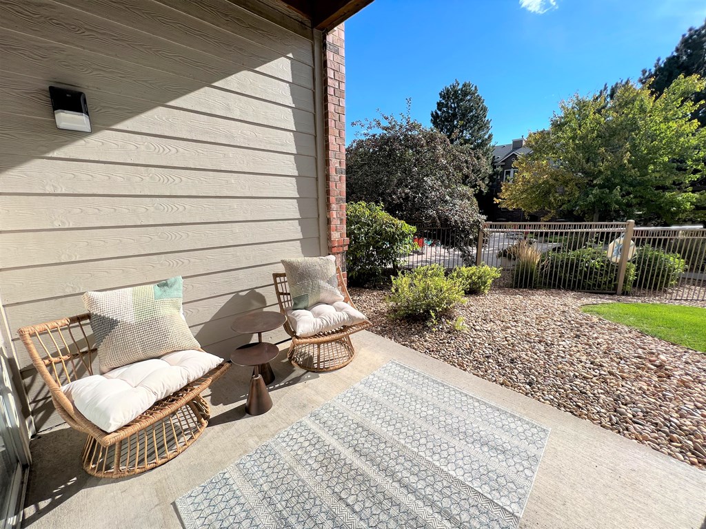 a patio with two chairs and a coffee table