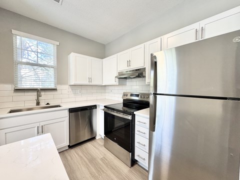 A kitchen with white cabinets and stainless steel appliances.