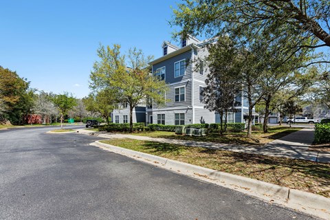 a house with a street and trees in front of it