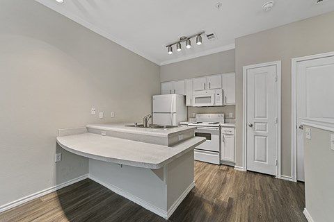 A kitchen with white cabinets and a white island.