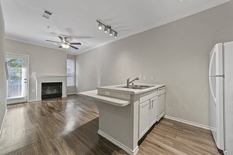 A kitchen with a white fridge and a fireplace.