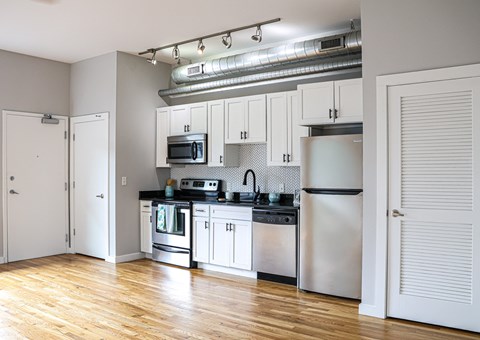 A kitchen with white cabinets and stainless steel appliances.