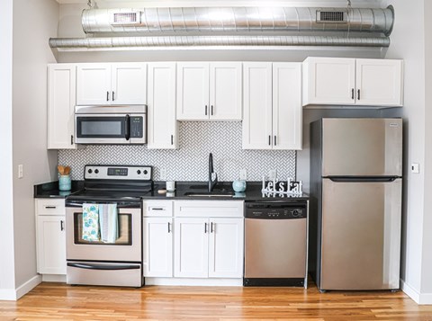 A kitchen with white cabinets and stainless steel appliances.