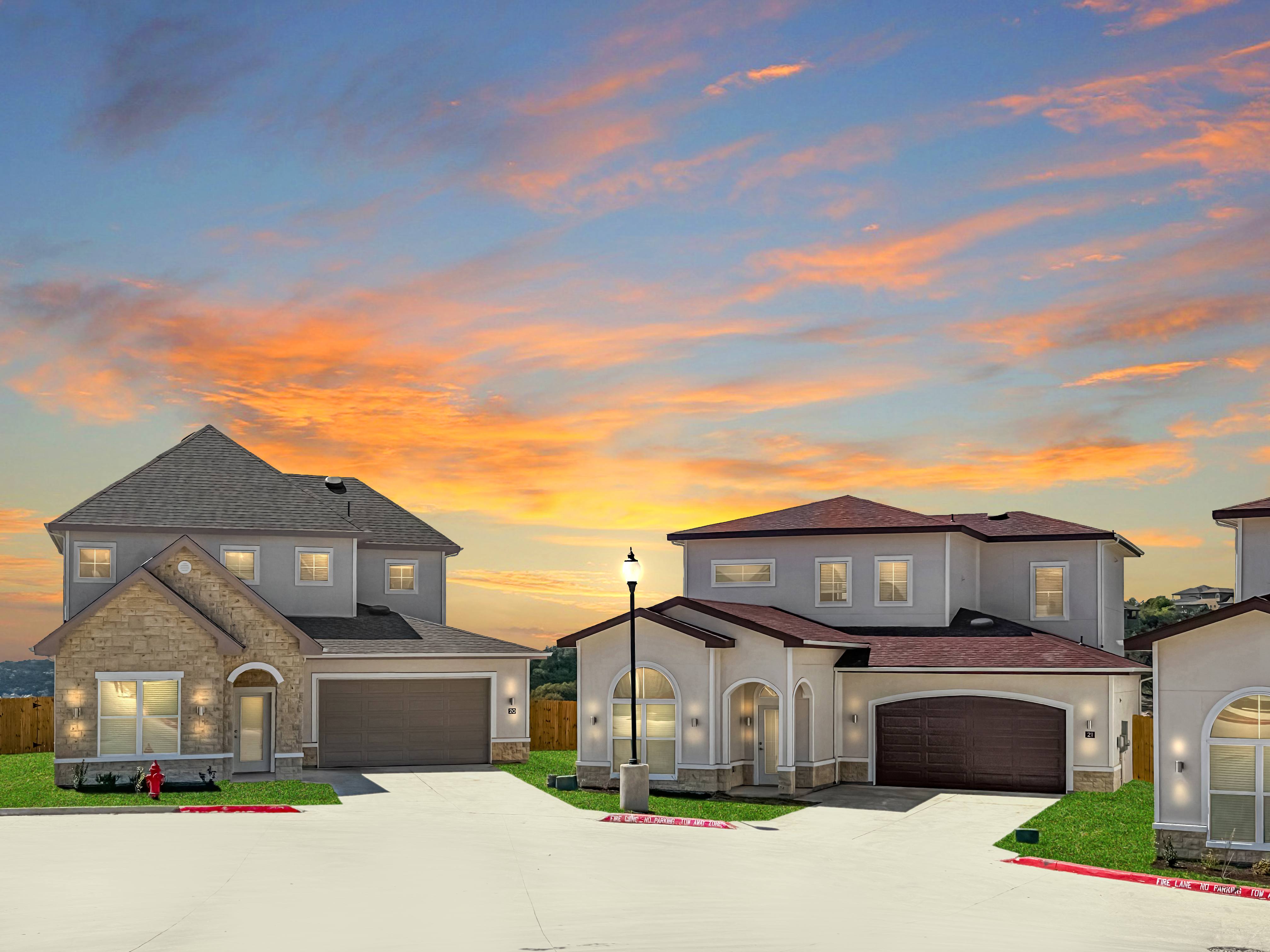 a large house with a sunset in the background