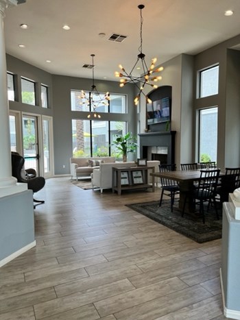 The Palms updated clubhouse, fireplace, tv, large floor to ceiling windows, two couches , large dining table - Photo Gallery 3