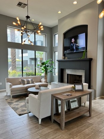 The Palms updated clubhouse, fireplace, tv, large floor to ceiling windows, two couches - Photo Gallery 2
