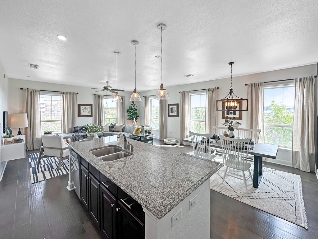 an open kitchen and living room with a large counter top
