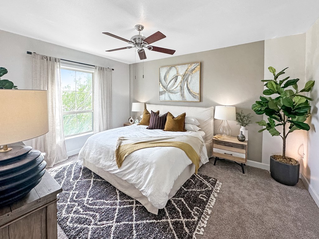 a bedroom with a bed and a ceiling fan