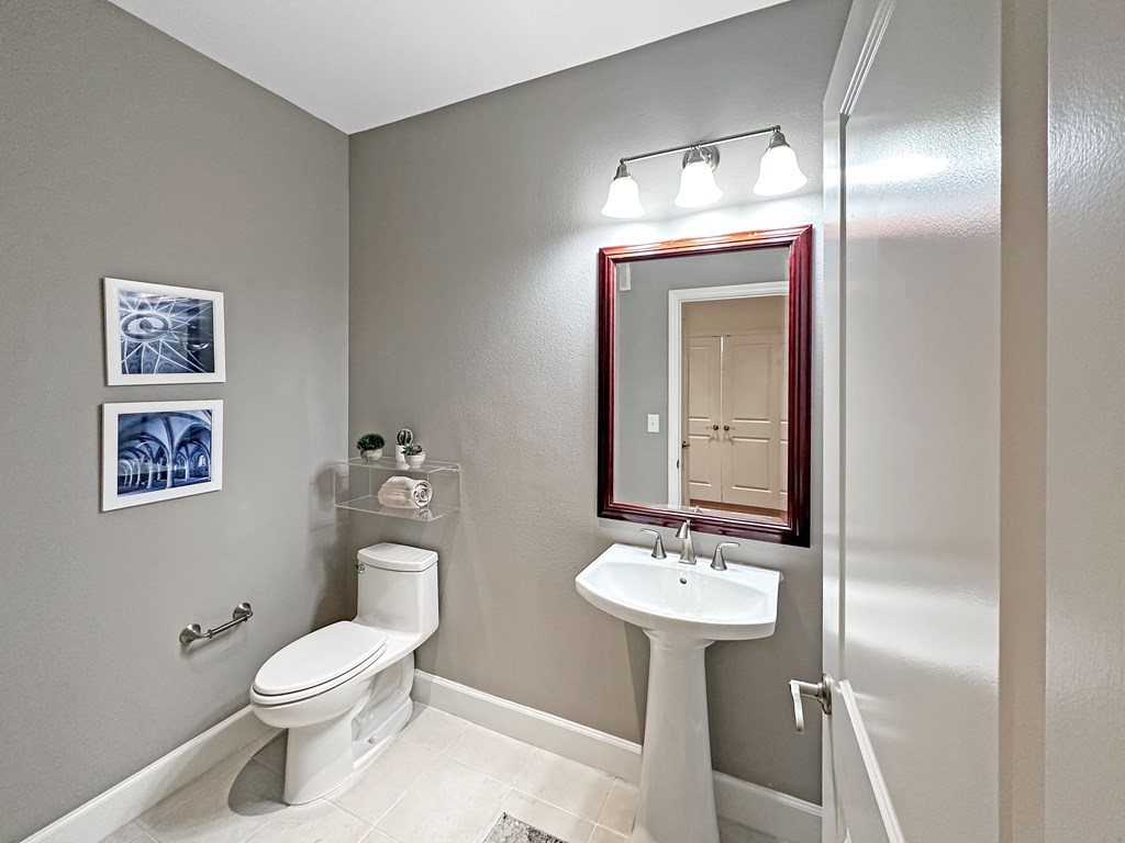 a bathroom with a toilet sink and mirror and a shower