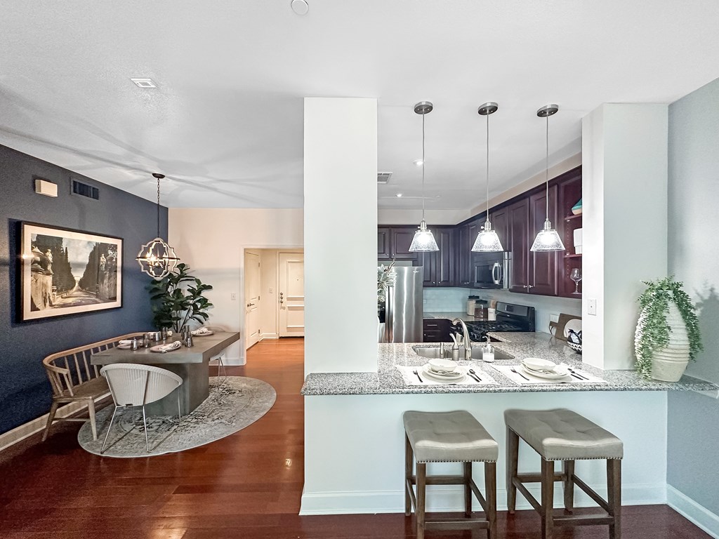a view of a kitchen and a living room with a table and chairs