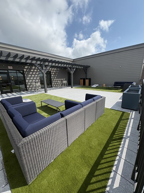 A modern building with a grey exterior and a blue sofa.