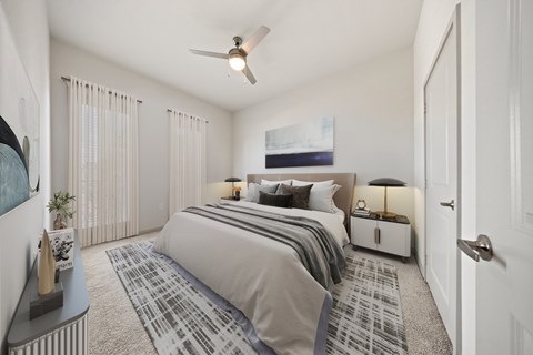 A bedroom with a large bed and a ceiling fan.