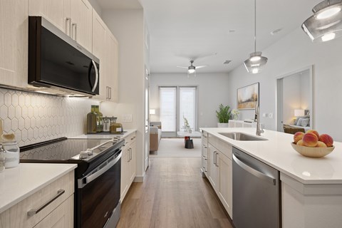 A modern kitchen with white cabinets and a black microwave.