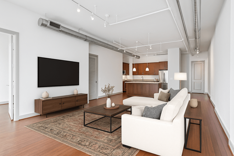 A living room with a white couch and a flat screen TV mounted on the wall.