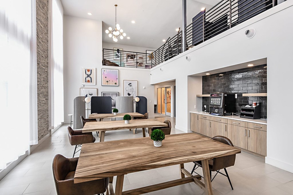 a dining room with wooden tables and chairs and a living room with a brick wall