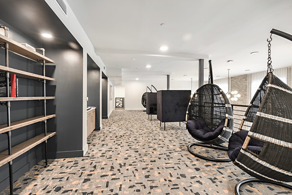 a living room with a swing chair and a book shelf